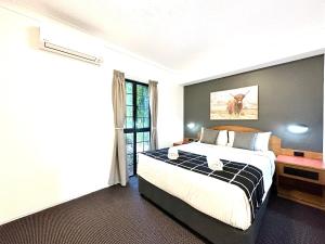 Mackay Resort Motel في ماكاي: غرفة نوم بسرير كبير ونافذة
