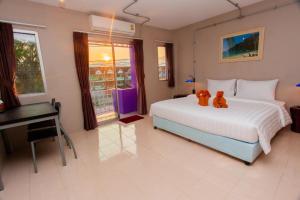 a bedroom with a bed with two teddy bears on it at khaolak big bike&room for rent in Khao Lak