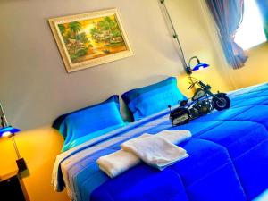 Un dormitorio con una cama azul con una motocicleta. en khaolak big bike&room for rent en Khao Lak