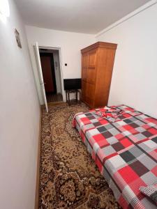 sypialnia z łóżkiem z kocem szachowym w obiekcie Apartament Adrian w mieście Eforie Nord