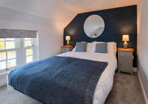 a bedroom with a large bed and a mirror at Hideaway Tyn Llan in Bryncroes