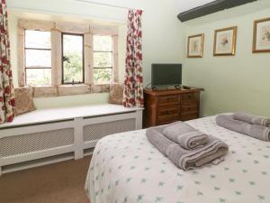 Un dormitorio con dos camas y una ventana. en Coln Cottage, en Stow on the Wold