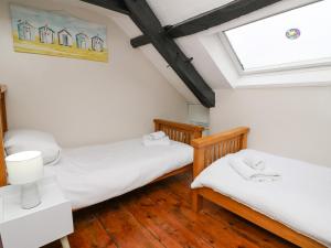 two twin beds in a room with a window at Eiddwen in Llanon