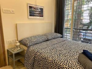 a bedroom with a leopard print bed and a window at Jastcon, 19th Rd, Khar, Ambedkar Colony by Connekt Homes in Mumbai