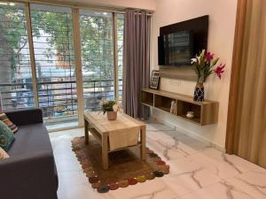 a living room with a couch and a tv at Jastcon, 19th Rd, Khar, Ambedkar Colony by Connekt Homes in Mumbai