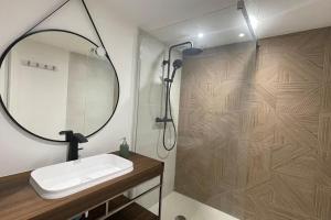 a bathroom with a sink and a shower with a mirror at Maison bretonne - cottage in Lézardrieux +15 photos