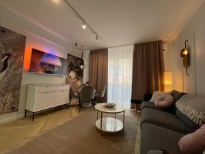 a living room with a couch and a table at Jeny Boutique Apartment in Târgu-Mureş
