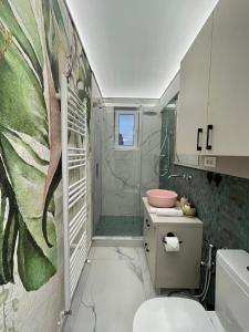 uma casa de banho com um chuveiro, um WC e um lavatório. em Jeny Boutique Apartment em Târgu-Mureş