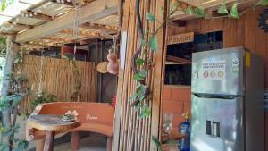 cocina con nevera, mesa y silla en Casa Aldairis, en Mazunte
