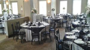 a room filled with tables and chairs with plates and glasses at Rocklin Park Hotel in Rocklin