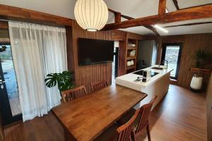 a kitchen with a large wooden table and a television at Jeju Sorakddele entire house in Jeju