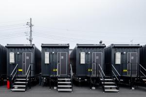 eine Gruppe von Containern, die auf einem Parkplatz geparkt sind in der Unterkunft HOTEL R9 The Yard Hitachinakaichige in Hitachinaka