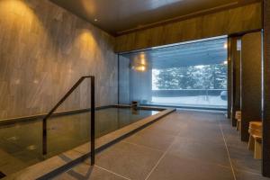 Higashiyama Niseko Village, a Ritz-Carlton Reserve في نيسيكو: مسبح في غرفة مع نافذة