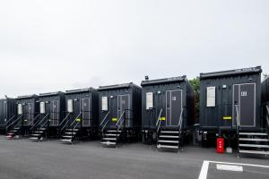 eine Reihe tragbarer Toiletten auf einem Parkplatz in der Unterkunft HOTEL R9 The Yard Hitachinakaichige in Hitachinaka