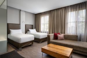 ケープタウンにあるプロテア ホテル バイ マリオット ケープ タウン ウォーターフロント ブレイクウォーター ロッジのベッド2台とソファが備わるホテルルームです。