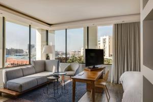 a hotel room with a couch and a bed and a tv at Protea Hotel by Marriott Cape Town Waterfront Breakwater Lodge in Cape Town