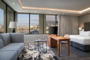 a hotel room with a bed and a couch at Protea Hotel by Marriott Cape Town Waterfront Breakwater Lodge in Cape Town