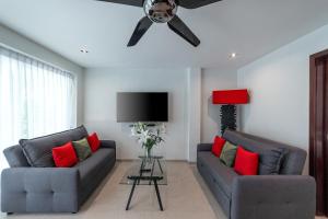 a living room with two couches and a ceiling fan at Villa of Siam in Ko Chang