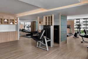 a gym with treadmills and exercise equipment in a room at Courtyard by Marriott Bangkok Sukhumvit 20 in Bangkok