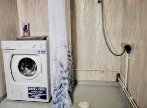 a washing machine in a bathroom with a shower at Jojos Lodge in Bräcke