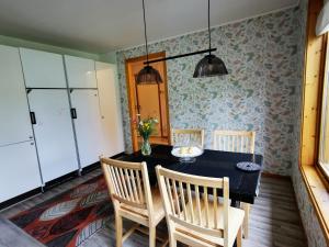 a dining room with a black table and chairs at Jojos Lodge in Bräcke