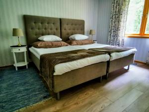 a bedroom with a large bed with a large headboard at Jojos Lodge in Bräcke