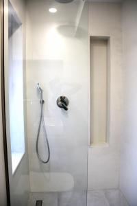 een badkamer met een douche en een glazen deur bij Aroa Eco Living Experience in Volímai