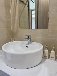 a white sink in a bathroom with a mirror at Tom homestay, căn hộ Nera garden Huế in Hue