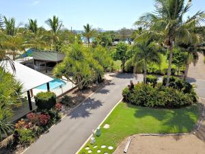 an aerial view of a resort with palm trees and a road at Woodgate Beach Houses in Woodgate