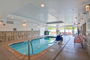 uma grande piscina interior num átrio do hotel com cadeiras em Courtyard by Marriott Long Island Islip/Courthouse Complex em Central Islip