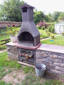 Kramolin的住宿－Вила Нина в Крамолин，花园里的室外砖炉,有桶