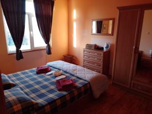 een slaapkamer met een bed met 2 handdoeken en een dressoir bij Вила Нина в Крамолин in Kramolin