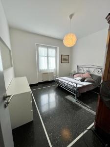 Un dormitorio con una cama en una habitación con ventana. en casetta sopra il mare, en Génova 6 fotos más