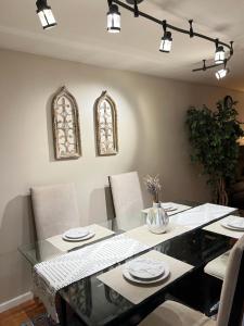 a dining room with a glass table and chairs at Luxe 3BR, 2BA + Hot Tub in Elmhurst