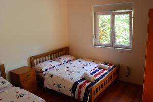 1 Schlafzimmer mit 2 Einzelbetten und einem Fenster in der Unterkunft Guesthouse Besimi in Valbonë