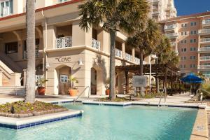 a swimming pool in front of a building with palm trees at Marriott Myrtle Beach Resort & Spa at Grande Dunes in Myrtle Beach