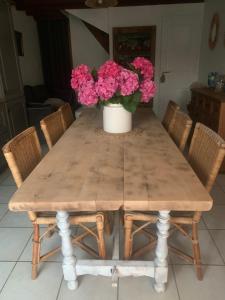 drewniany stół z wazonem kwiatów w obiekcie Agréable petite maison située au bord du Doubs w mieście Verdun-sur-le-Doubs