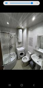 a bathroom with a toilet and a sink and a shower at Orbi Sea Towers in Batumi