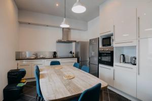 a kitchen with a wooden table and blue chairs at Coeur de ville #B2 - Centre ville, WIFI & NETFLIX - Proche transports - CHAMBRE PRIVEE dans logement partagé in Cholet