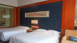 Duas camas num quarto com paredes azuis e laranja em Four Points by Sheraton Suzhou em Suzhou