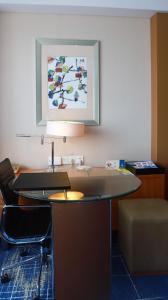 a room with a desk with a lamp and a chair at Four Points by Sheraton Suzhou in Suzhou