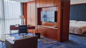 蘇州的住宿－蘇州福朋喜來登酒店，酒店客房设有一张床、一张书桌和一台电视机。