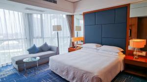 a bedroom with a large bed and a couch at Four Points by Sheraton Suzhou in Suzhou