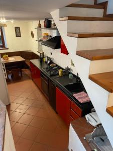 a kitchen with red cabinets and a stove top oven at Wedding and Family House in Malcesine