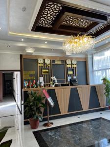 een hotellobby met een receptie en een kroonluchter bij Almaz Hotel Uzbekistan in Tasjkent