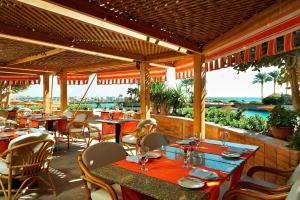 Hurghada Marriott Beach Resort في الغردقة: مطعم بطاولات وكراسي مطل على المحيط