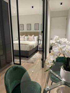 um quarto com uma cama e uma mesa de vidro com um espelho em Ellipse Waterfall luxurious unit em Midrand