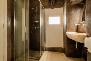 uma casa de banho com uma cabina de duche em vidro e um lavatório. em le CASINE di MARUGGIO 10 em Maruggio