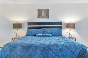 a blue bed with a blue comforter and two lamps at Beautiful Condo on the Beach in Freeport, Bahamas! in Pinders Point