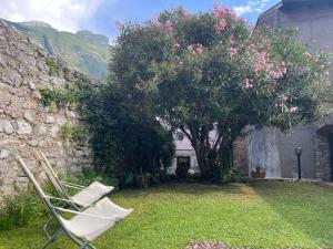 a couple of lawn chairs sitting next to a tree at Wedding and Family House in Malcesine